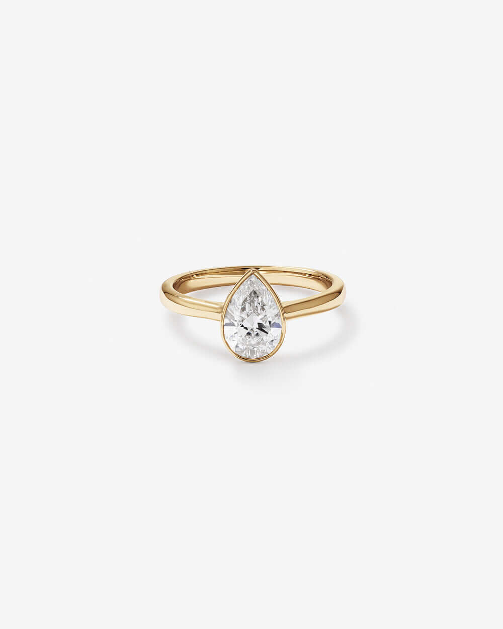 Pear Cut Bezel Set Engagement Ring featuring a sparkling pear-cut diamond in a sleek gold band.